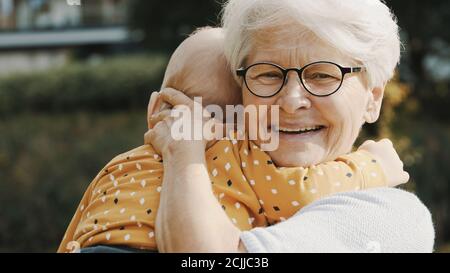 primo piano, felice nonna abbracciando il nipote in natura. Foto di alta qualità Foto Stock