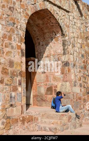 Un ragazzo indiano che siede e scattando l'immagine del vecchio forte che dà la posa per sparare di moda. Foto Stock