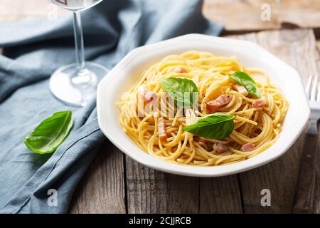 Pasta italiana carbonara a base di uova, formaggi stagionati, guanciale di maiale o pancetta e pepe nero. Cucina tipica in Italia, primo piano Foto Stock