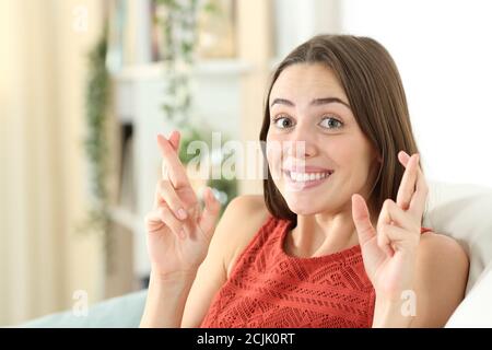 Felice teen che attraversa le dita sittig su un divano nel soggiorno a casa Foto Stock