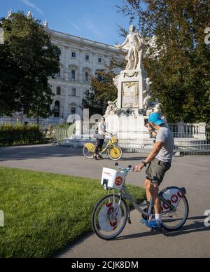 I turisti si scattano foto l'uno dell'altro di fronte alla statua di Mozart a Burggarten, Vienna, Austria Foto Stock