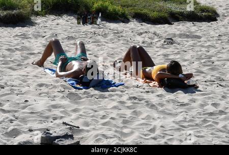 Rodenkirchen, Germania. 15 settembre 2020. Un uomo e una donna che prendono il sole sulla spiaggia del Reno. Le temperature dovrebbero raggiungere i 34 gradi di mercoledì. Credit: Roberto Pfeil/dpa/Alamy Live News Foto Stock