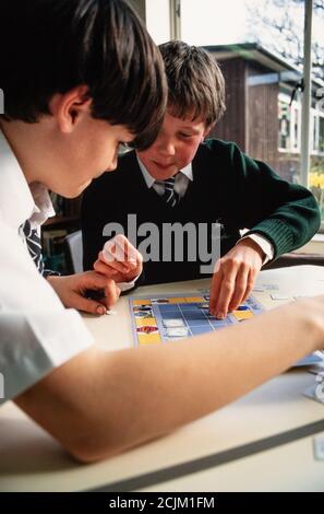 I bambini della scuola elementare alla scuola di Raleigh a West Horsley, Surrey usando un semplice gioco da tavolo come dispositivo di apprendimento. 22 novembre 1993. Foto: Neil Turner Foto Stock