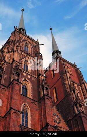 Vista dal basso verso l'alto di due torri in mattoni della cattedrale gotica di San Giovanni Battista a Ostrow Tumski Wroclaw, Polonia Foto Stock