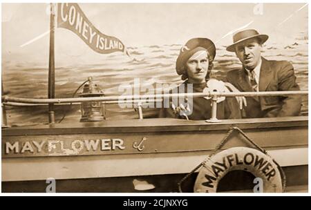 Una cartolina fotografica di circa anni '30 dei visitatori seduti nello stand fotografico della nave Mayflower presso l'area dei divertimenti di Coney Island, situata su una penisola nella parte sud-occidentale di Brooklyn, New York City, USA. Migliaia di visitatori del complesso di intrattenimento hanno pagato per avere la loro fotografia scattata nello stesso luogo ogni anno per commemorare il simbolismo culturale dell'icona di Mayflower, particolarmente quelli che sono arrivati come nuovi coloni stessi alla 'terra promessa'. Si ritiene che il nome della zona sia nato dall'olandese "Conyne Eylandt", che significa l'isola dei conigli. Foto Stock