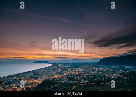 Terracina, Italia. Vista dall'alto skyline città in serata Tramonto. Illuminazioni cittadine Foto Stock