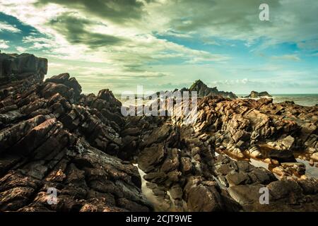 la formazione naturale di roccia a riva del mare a causa delle onde che si infrangono al mattino da un'immagine ad angolo piatto è presa alla spiaggia om gokarna karnataka india Foto Stock