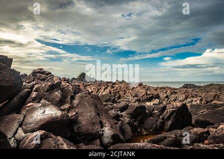 la formazione naturale di roccia a riva del mare a causa delle onde che si infrangono al mattino da un'immagine ad angolo piatto è presa alla spiaggia om gokarna karnataka india Foto Stock