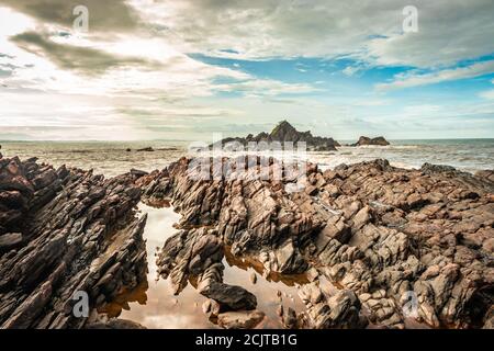 la formazione naturale di roccia a riva del mare a causa delle onde che si infrangono al mattino da un'immagine ad angolo piatto è presa alla spiaggia om gokarna karnataka india Foto Stock