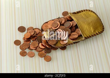 Alto angolo di ripresa di monete centesimi di euro in sparso fuori di una piccola borsa Foto Stock