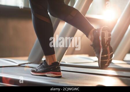 Primo piano di donna in abbigliamento sportivo che corre sul tapis roulant in palestra Foto Stock