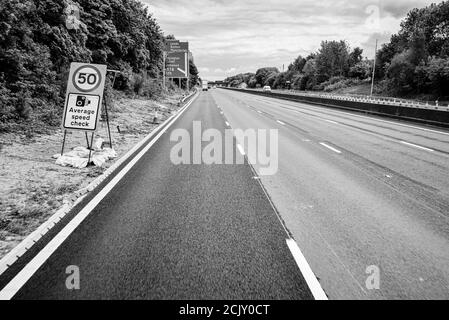 Lavori stradali in corso e traffico in movimento sull'autostrada M62 in Inghilterra. Mostra limite di velocità Foto Stock