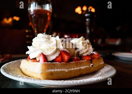 Waffle con fragole, panna e birra in un ristorante di Bruges, Belgio Foto Stock