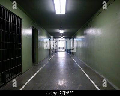Rundown corridoio della cella di prigione in una struttura di proprietà del governo inutilizzata. Foto Stock