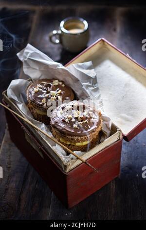 Muffin alla crema di cioccolato. Dessert dolce in scatola. Stile country. Cibo e bevande salutari. Foto Stock