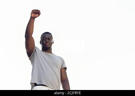 Primo piano di un giovane nigeriano in tessuto bianco in piedi con la mano destra in su Foto Stock