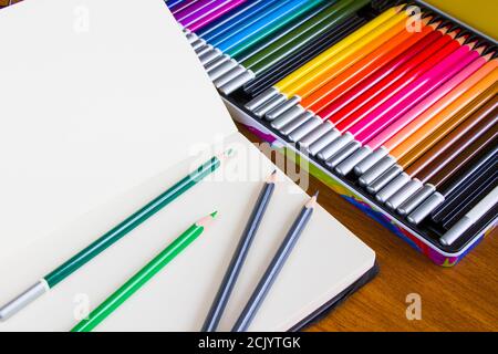 Tabella di disegno e pittura, disegno di matite e album, carta vuota e matite colorate Foto Stock