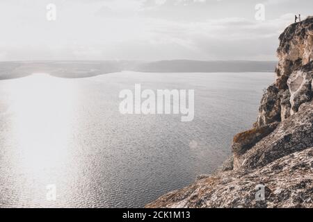 Enormi rocce di pietra chiara sopra un ampio e pulito lago sotto il sole Foto Stock