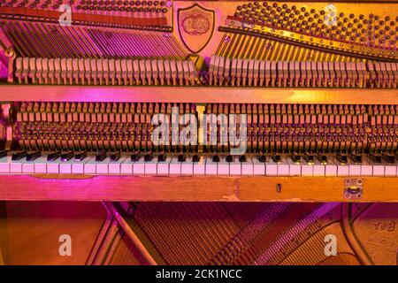 Le lavorazioni interne di un pianoforte verticale che mostra le corde e i martelli all'interno. Foto Stock