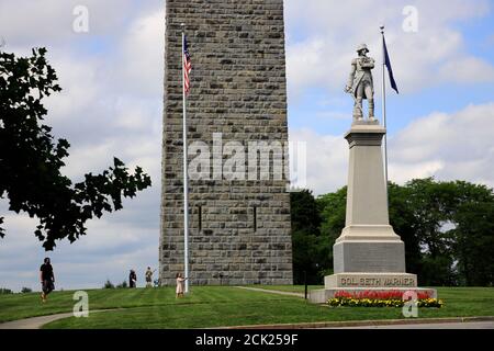 Statua del colonnello continentale Seth Warner con la battaglia di Bennington Monumento in background.Bennington.Vermont.USA Foto Stock