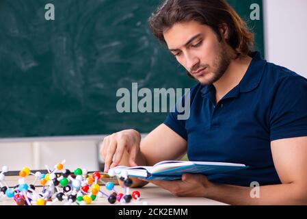 Giovane scienziato seduto in classe Foto Stock