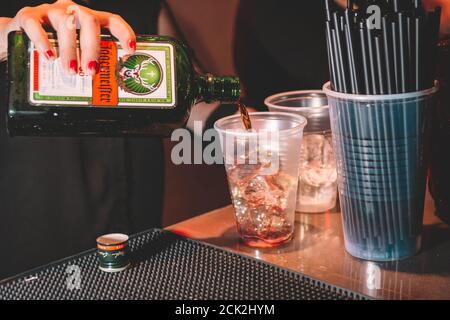 Buenos Aires, Argentina; 7 gennaio 2018: Donna che serve Jagermeister in una tazza di plastica con ghiaccio. Foto Stock