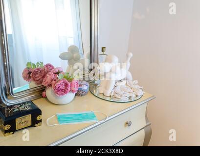 Immagine verticale di una maschera medica su un ripiano di legno - nuovo normale Foto Stock