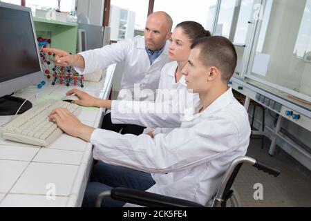 giovane in sedia a rotelle durante una lezione di scienza Foto Stock