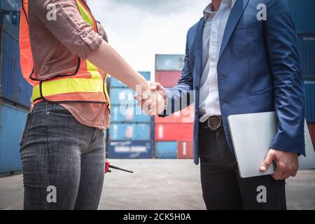 Businessman and Container Shipping Worker Handshake insieme per la cooperazione spedizione in Logistic Warehouse, Business Partnership saluto Handshaking Foto Stock