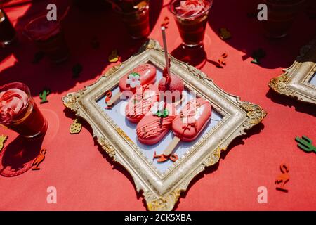 Carino tavolo rosa per una festa estiva nel cortile. Torte e dolci rosa sul tavolo Foto Stock