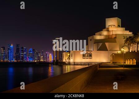 Doha, Qatar - 26 agosto 2020: Museum of Islamic Art Building a Doha, Qatar, con skyline notturno sullo sfondo e riflessione sull'acqua della baia Foto Stock