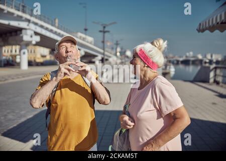 Uomo anziano che rifornisce gli elettroliti persi dopo l'esercitazione Foto Stock