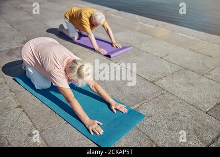 Donna e un uomo dai capelli grigi che fa yoga Foto Stock