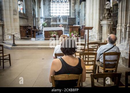 indietro vedere le persone che pregano all'interno di una chiesa Foto Stock