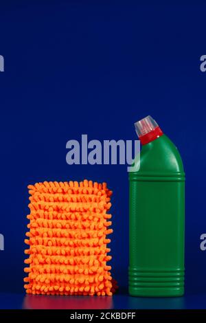 panno per mop e bottiglia verde con agente di lettura su sfondo blu. Foto Stock