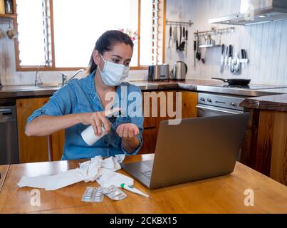 COVID-19 Consulenza medica online. Donna malata con maschera di collegamento con il medico in videochiamata. Paziente in linea che parla con il medico per l'advic medico Foto Stock