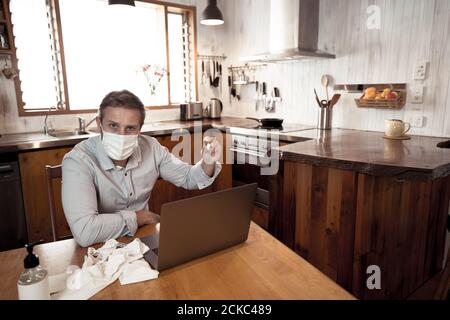 COVID-19 Consulenza medica online. Uomo malato con maschera di collegamento con il medico in videochiamata. Paziente online che parla con il medico per consulenza medica Foto Stock