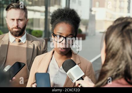 Donna d'affari africana intervistata sulla strada con cui parla giornalisti Foto Stock