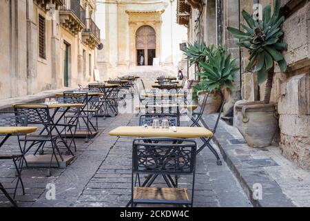 Graziosa caffetteria con posti a sedere all'aperto all'esterno della Chiesa di Montevergine (conosciuta anche come San Girolamo), una chiesa barocca cattolica di noto - Sicilia, Italia Foto Stock