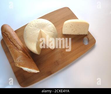 Testa rotonda di formaggio con baguette su una tavola di legno primo piano. Foto di alta qualità. Foto Stock