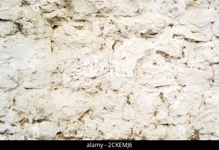 Sfondo di vecchio danneggiato muro di pietra incrinato struttura con cemento Foto Stock