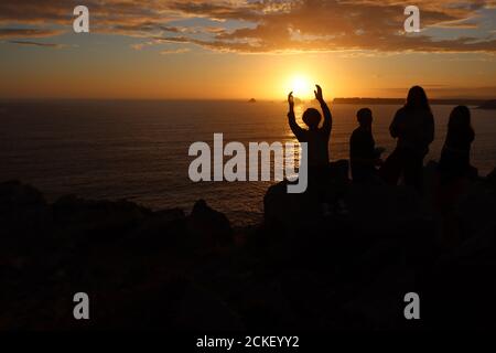 Gruppo di bambini al tramonto su calze al mare Foto Stock