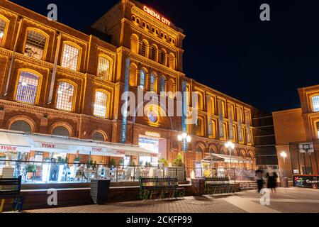 Lodz, Polonia - 6 agosto 2020: Cinema City edificio al centro commerciale Manufaktura e complesso ricreativo illuminato di notte Foto Stock