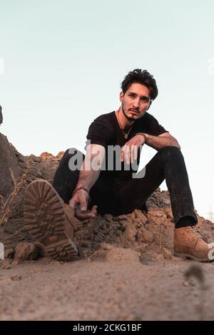 ritratto di un giovane in un vestito nero in un deserto Foto Stock