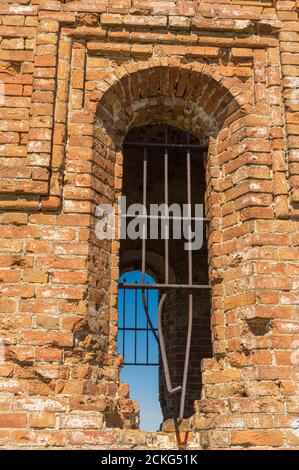 Antica finestra grattugiata in un vecchio edificio in mattoni Foto Stock