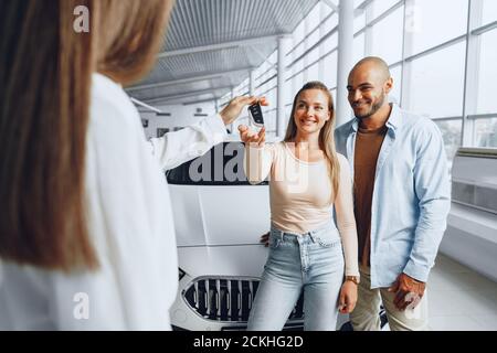 Venditore di automobili in un concessionario di automobili che ha un colloquio con clienti Foto Stock