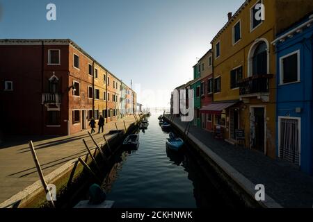 La vista di case colorate lungo il canale d'acqua sull'isola di Burano durante un tramonto, Veneto, Italia Foto Stock