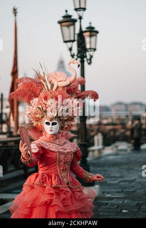 Costume/maschera carnevale tradizionale che posa la mattina presto sul lungomare durante un alba al carnevale annuale a Venezia, Italia Foto Stock