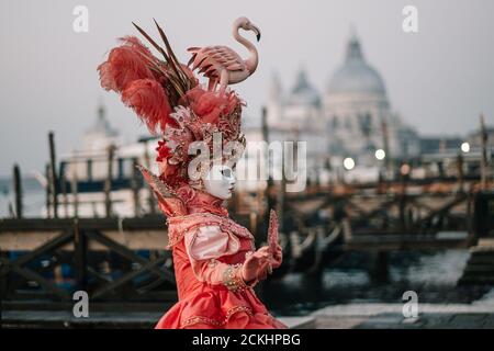 Costume/maschera carnevale tradizionale che posa la mattina presto sul lungomare durante un alba al carnevale annuale a Venezia, Italia Foto Stock