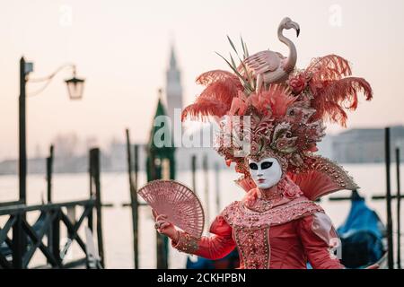 Costume/maschera carnevale tradizionale che posa la mattina presto sul lungomare durante un alba al carnevale annuale a Venezia, Italia Foto Stock